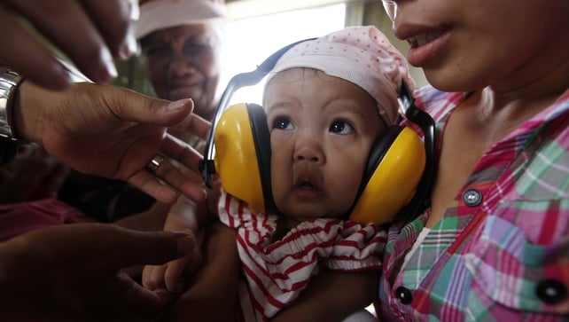 A mother cuddles her sick baby on board a military helicopter in the devastated town of Guiuan