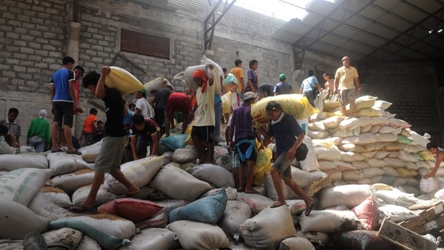 Residents loot water damaged sacks of rice from a warehouse in Tacloban