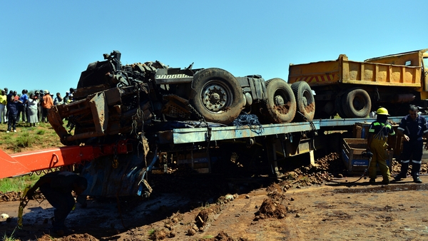 Emergency services clear the scene after a truck collided with a bus filled with commuters, killing 29 people