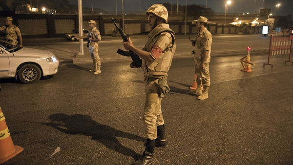 Egyptian troops keep watch at a checkpoint during the curfew hours in Cairo last August