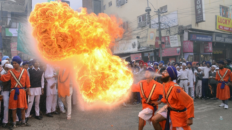 Indian Sikh Nihang warriors perform a fire breathing act during a procession from Sri Akal Takhat to the Golden Temple in Amritsar
