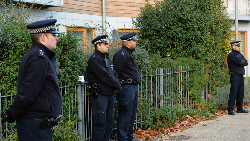 Police stand guard outside a block of flats in south London