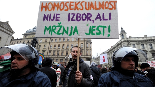 A protester holds a sign reading 'Homosexuality is not a choice, hate is a choice' next to riot policemen as Croatian gay rights activists protest in Zagreb