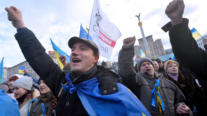 People shout slogans and wave flags of Ukraine and the European Union during a rally on Independence Square in Kiev