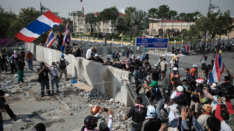 Anti-government protesters pull down the last concrete barricade after the police let them through outside Government House