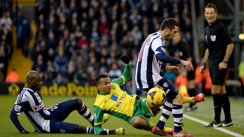 Norwich's Martin Olsson is swamped by Youssouf Mulumba and Diego Lugano of WBA