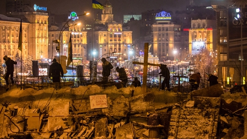 Protesters use snow to reinforce a barricade blocking street access to Independence Square