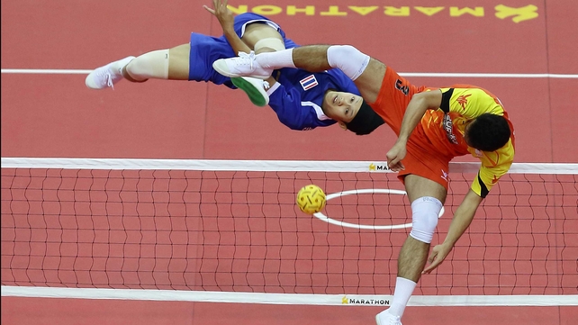 Mohd Hanafiah Dolah attempts to block a Sahachatt Sakhoncharoen strike during the Sepaktakraw Team event at the SEA Games in Nay Pyi Taw, Burma