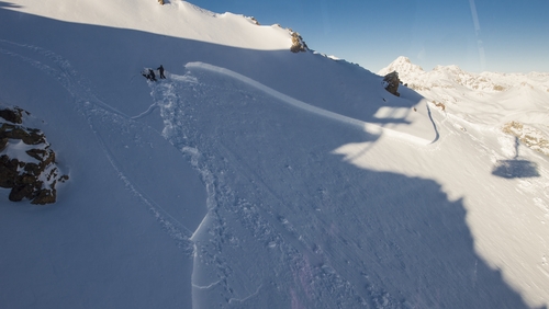 Avalanche experts are seen near the edge of an avalanche in the Swiss Alps