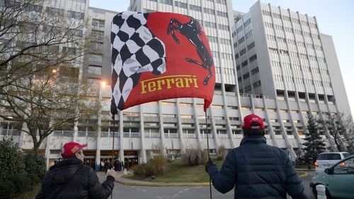 Fans hold a Ferrari flag in front of the Grenoble University Hospital Centre in support of Michael Schumacher