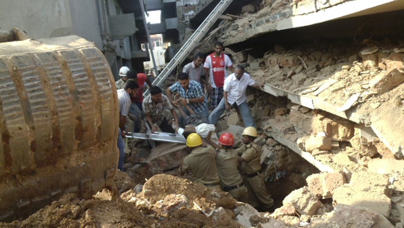 Rescue workers pull a victim from the rubble of a collapsed building in Goa