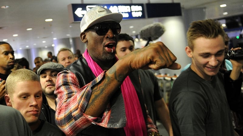 Former NBA basketball player Dennis Rodman (C) walks through Beijing's international airport, with Today FM's Matt Cooper seen over his shoulder