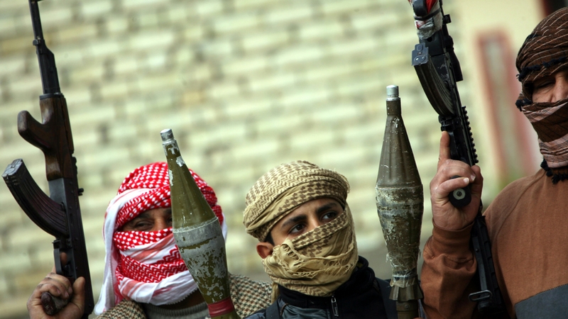 Sunni fighters carry RPG missiles launcher and machine guns as they take up position in Fallujah