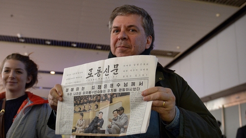 A man shows a North Korean newspaper as he arrives at Beijing's international airport from North Korea