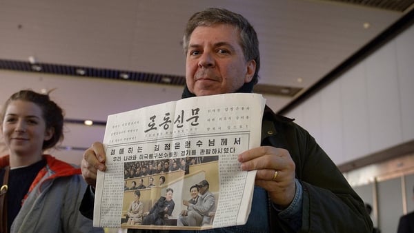 A man shows a North Korean newspaper as he arrives at Beijing's international airport from North Korea