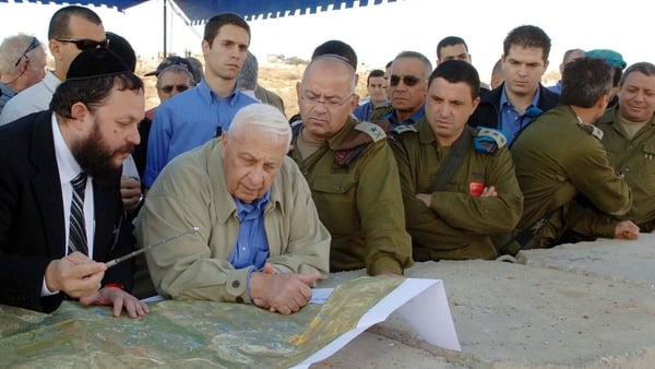 Mr Sharon is briefed by Yaakov Guterman on the route of Israel's separation barrier in Modi'in Illit