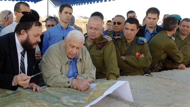 Mr Sharon is briefed by Yaakov Guterman on the route of Israel's separation barrier in Modi'in Illit in 2005