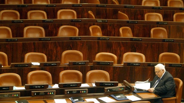 Mr Sharon sits alone as he attends a session of the Israeli Parliament in February 2003