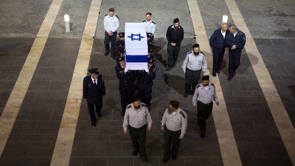 Israeli honour guards carry the coffin into the Knesset