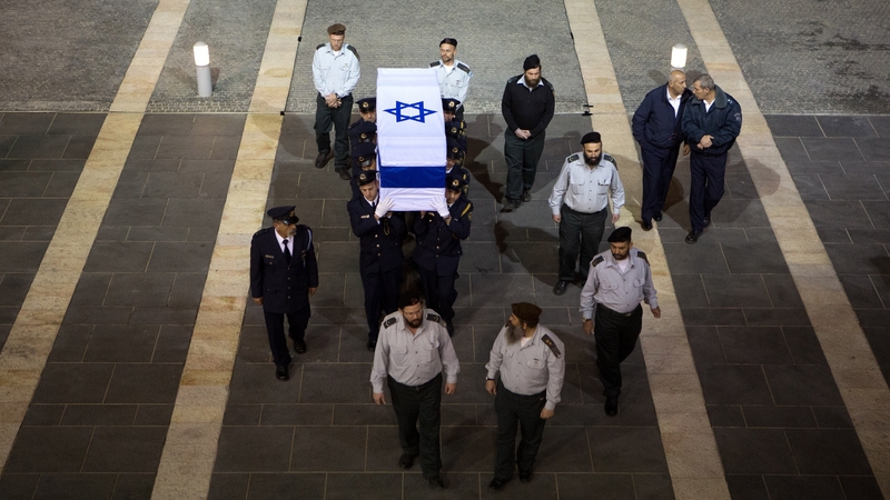 Israeli honour guards carry the coffin into the Knesset