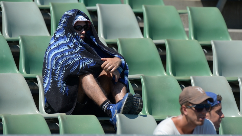 A fan covers himself from the heat with a towel at the Australian open