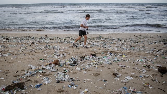 A man jogs along amid the litter