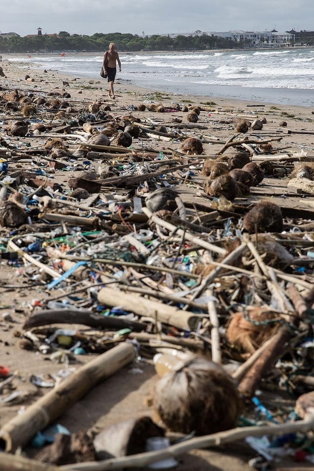 A man walks along the nearly covered beach