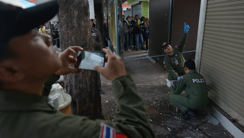 The Thai bomb squad unit examine the site of a blast at Victory monument in Bangkok