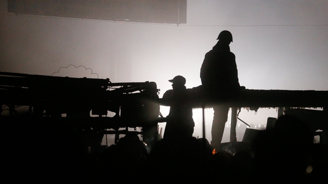 Protesters are seen standing on a burned car in the centre of Kiev