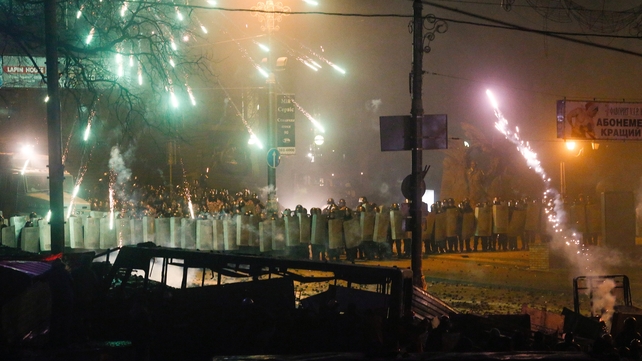 Protesters fire fireworks to a police line