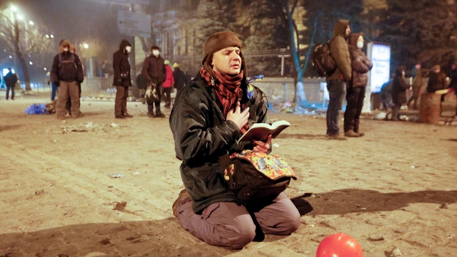 A protester prays as he holds an open Bible during the anti-government protest