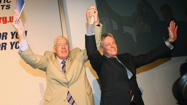 Mr Paisley holds up his hands with Peter Robinson as he arrives for his farewell speech at Balmoral Hall in Belfast on 30 May 2008