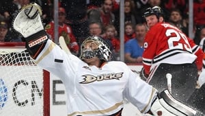 Jonas Hiller of the Anaheim Ducks tries to make a save on a goal shot by Bryan Bickell of the Chicago Blackhawks in Chicago