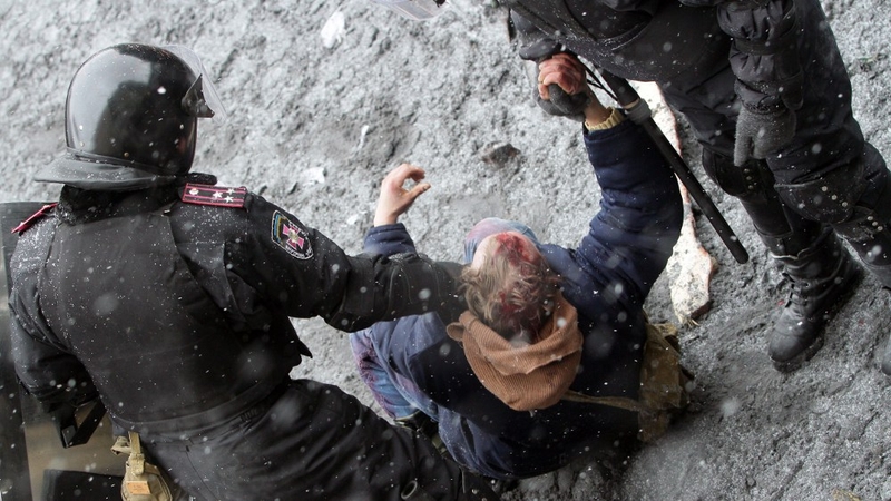 Ukrainian riot policemen detain a protester following clashes in central Kiev