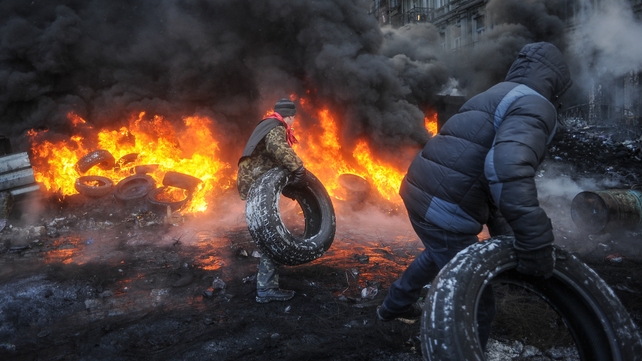 Protesters burn tires as they clash with riot police (Pic: EPA)