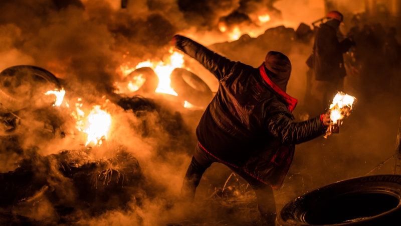 Masked men hurled Molotov cocktails and tyres into the burning flames