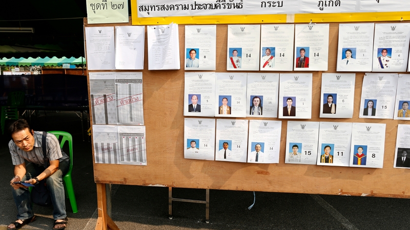 An official sits by an early polling station that was blockaded by protesters