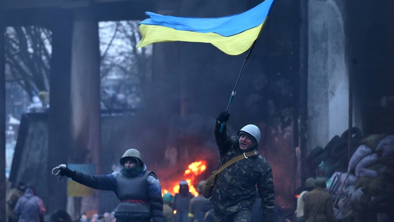 A protester waves a Ukrainian national flag near one of the barricades in Kiev (Pic: EPA)