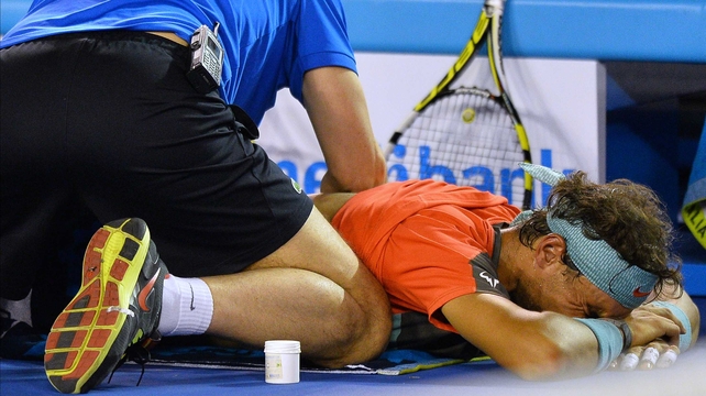 Rafael Nadal receives treatment from an official during the Australian Open men's singles final against Switzerland's Stanislas Wawrinka