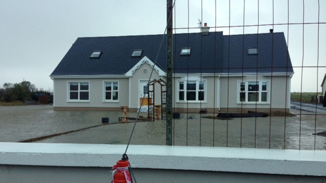 A house in Quilty, Co Clare stands isolated by flood waters