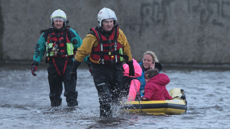 Residents use a boat to navigate flood waters on the Lee Estate
