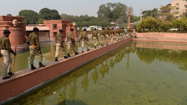Indian policemen walk single file over a pond following demonstrations outside the Parliament by supporters demanding a separate state of Telangana