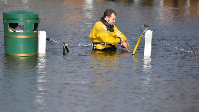 A firefighter wades through chest high water in the flooded village of Datchet, west of London