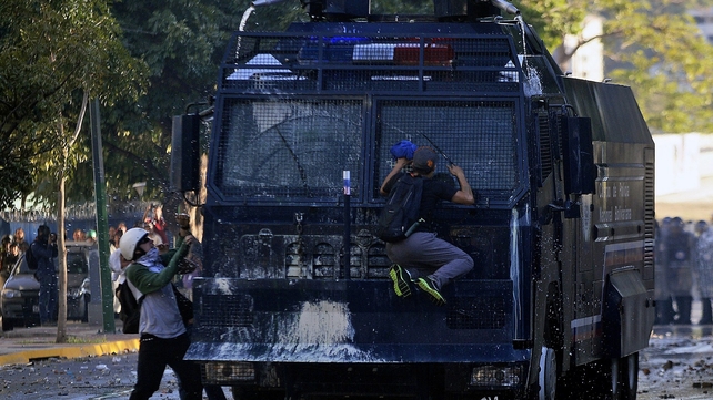 Anti-government students attack a water cannon during a protest in Caracas. Supporters and opponents of Venezuela's leftist government staged rallies in the capital.