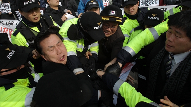 South Korean conservative protesters scuffle with riot police as police seize a North Korean flag from the demonstrators during an anti-North Korea protest in Seoul. The rally coincided with North Korean leader Kim Jong Il's birthday.