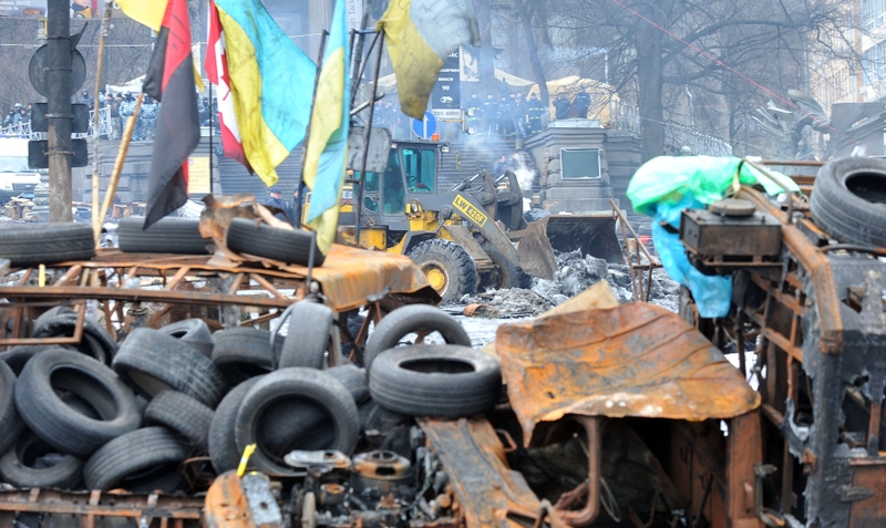 A backhoe loader tractor of the Kiev communal services removes an opposition barricade on Grushevsky street