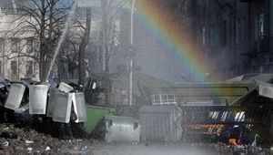 Protesters clash with riot police as a rainbow appears during continuing protests in downtown Kiev (EPA)