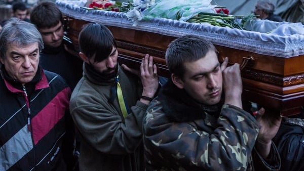 The body of one of yesterday's victims is carried through Independence Square