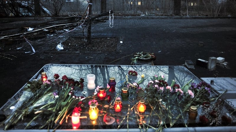 A rosary hangs on a tree at an improvised memorial for demonstrators killed in the capital
