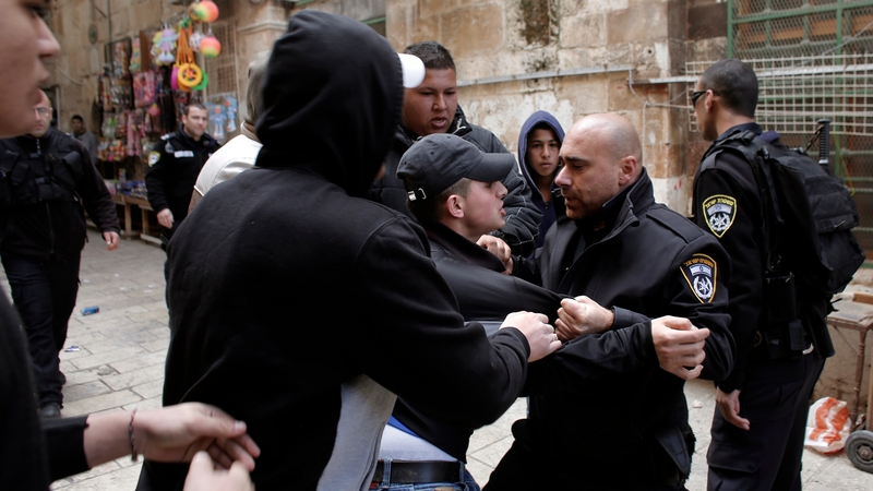 Palestinian men scuffle with Israeli police at an alleyway leading to the al-Aqsa Mosque compound